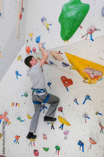 Sporty man climbing on climbing wall.