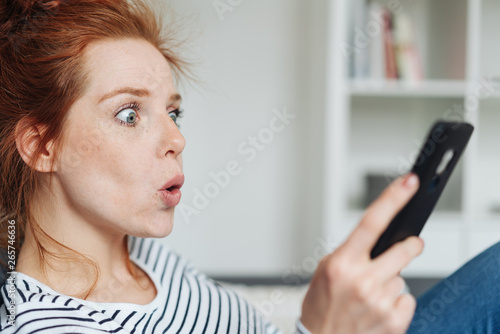 Shocked young woman reacting in amazement