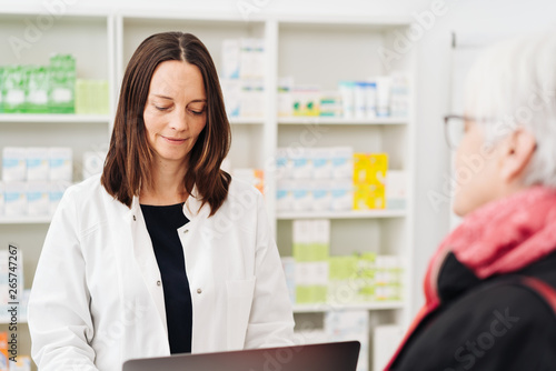 Female pharmacist assisting an elderly woman