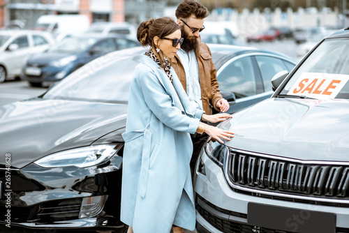 Young stylish couple choosing luxury car to buy on the open ground of the dealership © rh2010