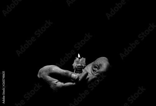 Man holds a candle stub in his hands.