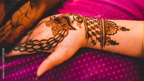 Slika na platnu henna tattoo being applied on a women's hand.
