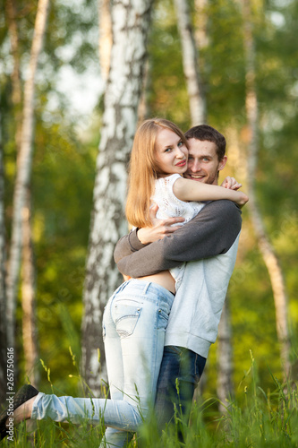 Happy lovers hugging in the birch grove