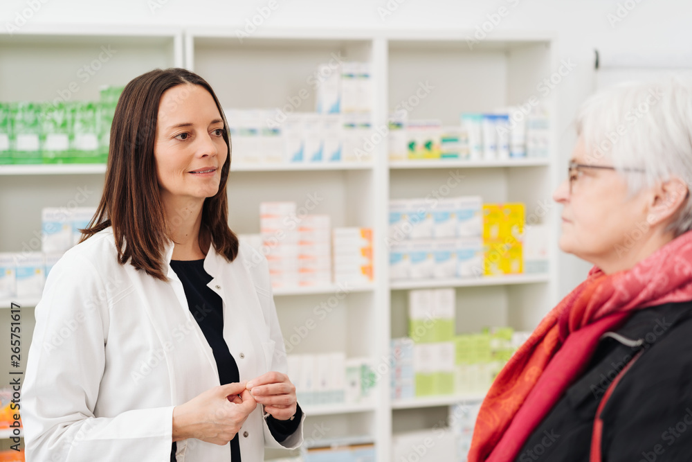 Female pharmacist listening to en elderly patient