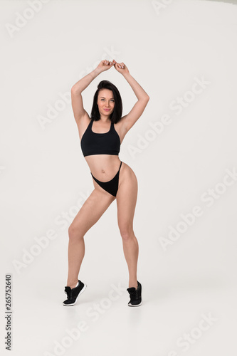 Muscular sexy fit young woman posing isolated on white background