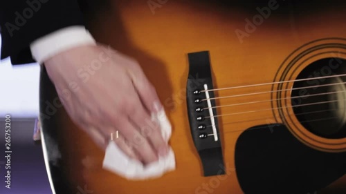 Guitarist rubs the guitar white cloth from dust photo