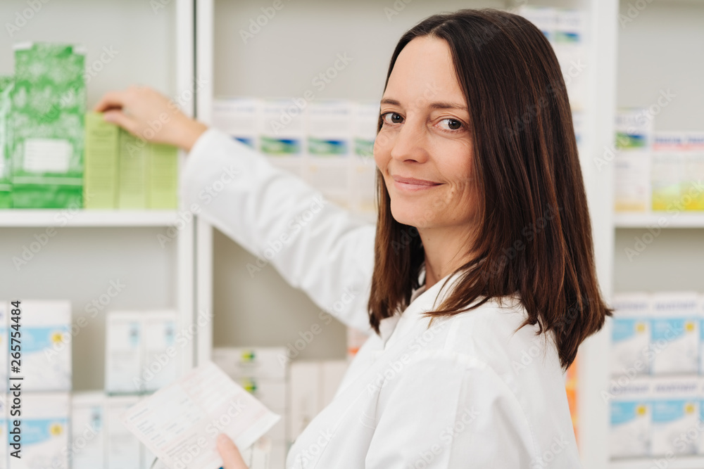 Smiling female pharmacist checking a prescription Smiling female pharmacist checking a prescription