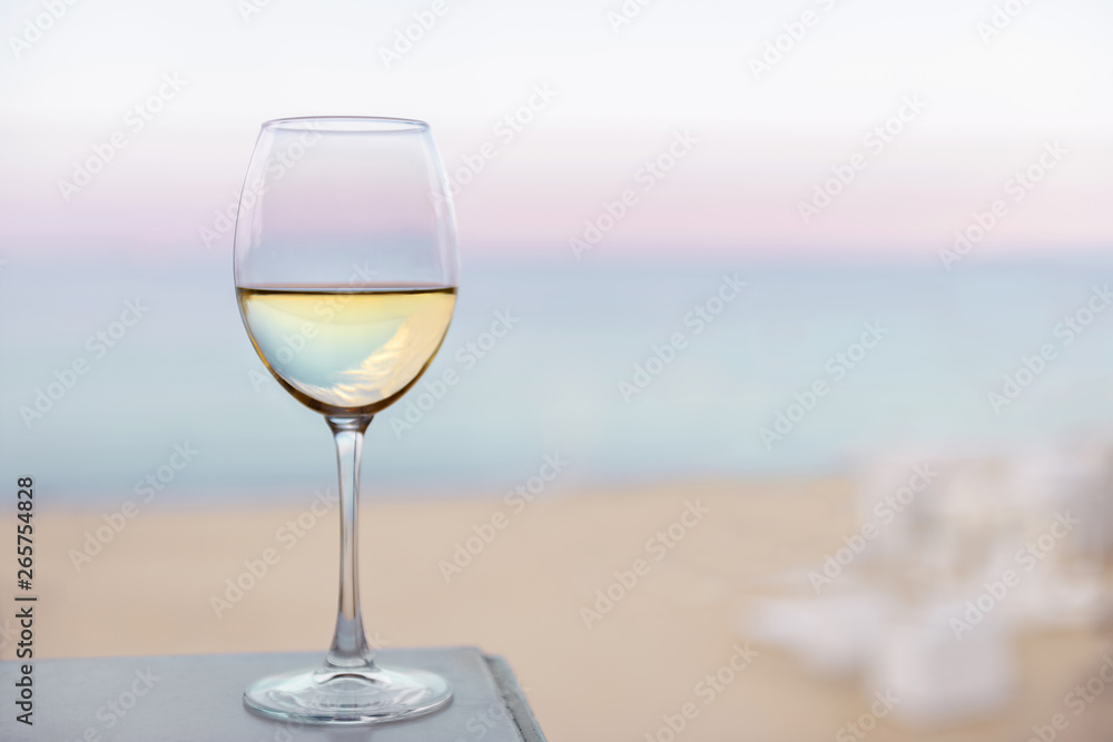 A glass of white wine on the sea beach