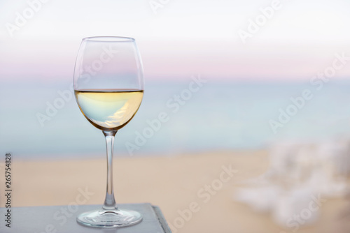 A glass of white wine on the sea beach