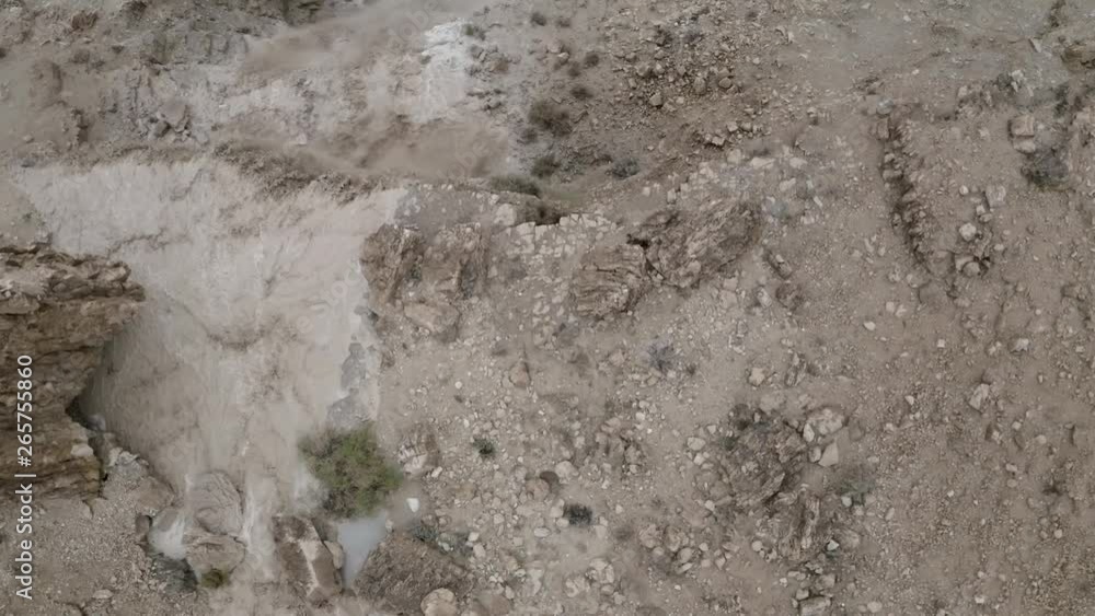 Aerial shot of desert cliff waterfall, brown water after desert flood, natural phenomenon in Israeli desert Aerial shot of desert cliff waterfall, brown water after desert flood, natural phenomenon in Israeli desert