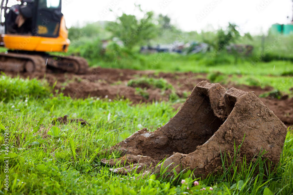 Obraz premium The excavator levels the earth on the site