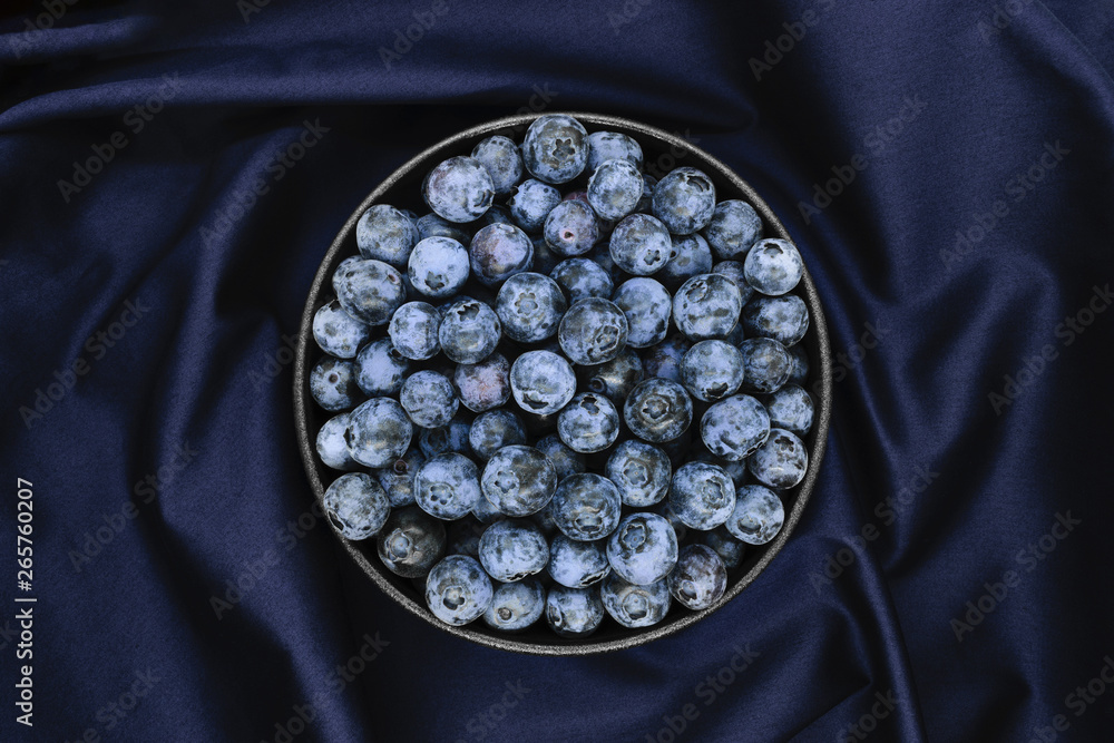 Fotografie Blueberries on blue fabric background