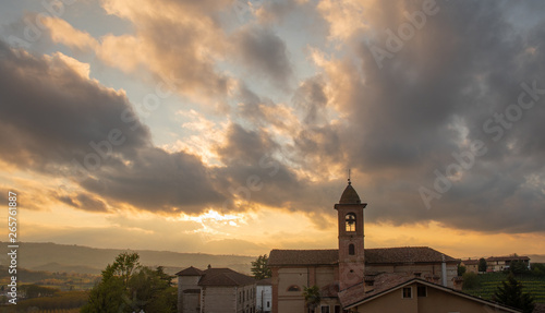 High angle view of the ancient village of Grinzane Cavour in the Langhe region of Piedmont, Unesco World Heritage Site since 2014, with a dramatic, cloudy sky at sunset, Italy 
