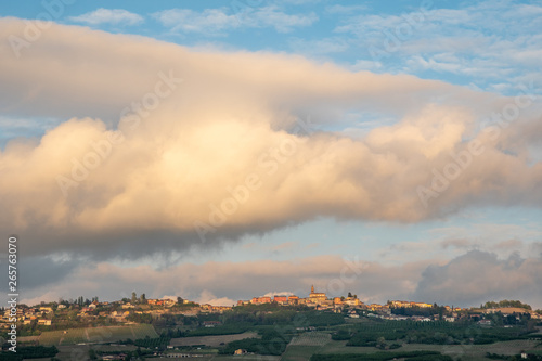 Scenic view of the ancient village of Diano d'Alba on the top of a vineyard hill in the Langhe region of Piedmont (Unesco World Heritage Site since 2014) with a cloudy sunset sky in springtime, Italy