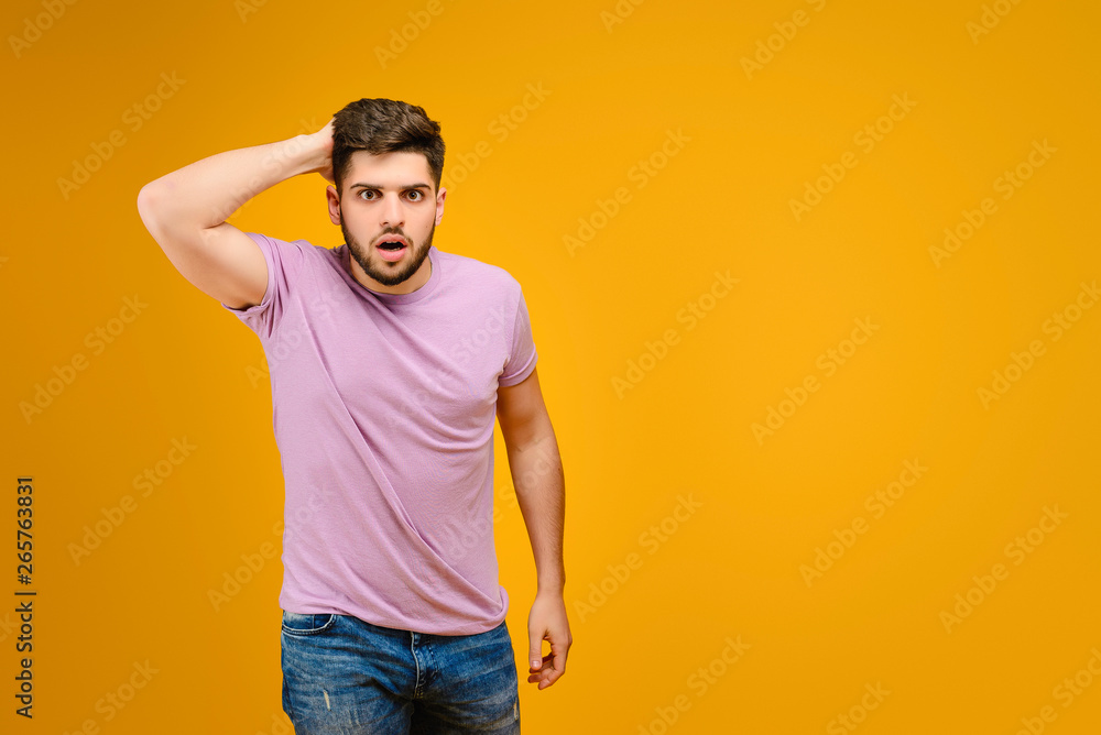 Young man surprised isolated over yellow background Young man surprised isolated over yellow background