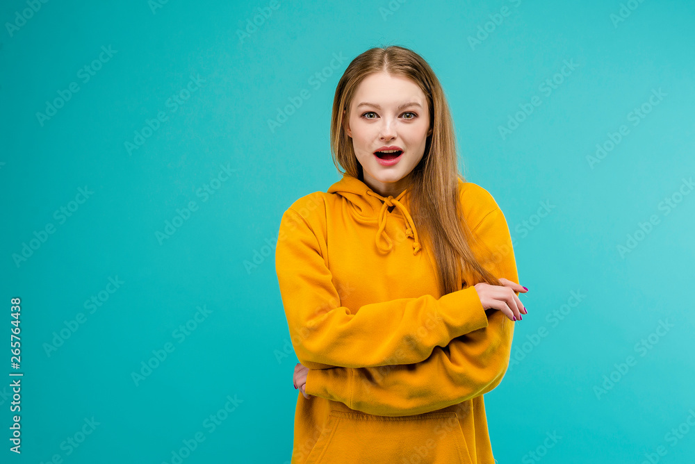 Obraz premium Portrait of an excited young woman isolated over bright blue background