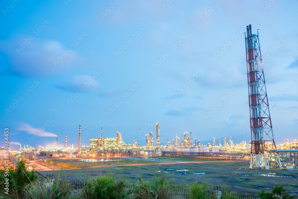 Obraz premium Oil refineries and oil depots and close-up of pipelines and destillation tanks of an oil-refinery plant in the evening