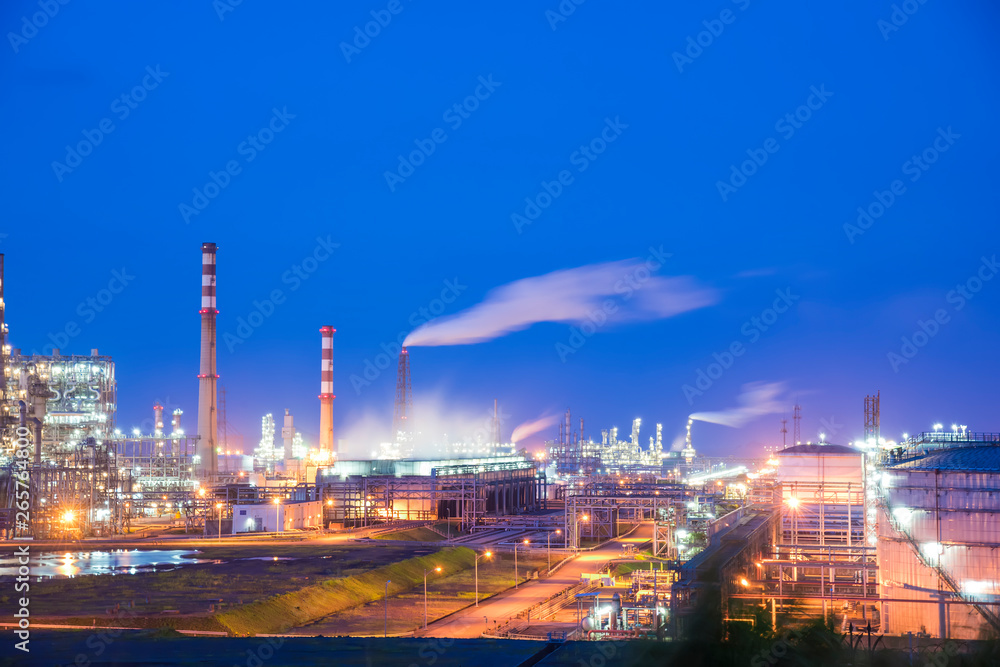 Oil refineries and oil depots and close-up of pipelines and destillation tanks of an oil-refinery plant in the evening