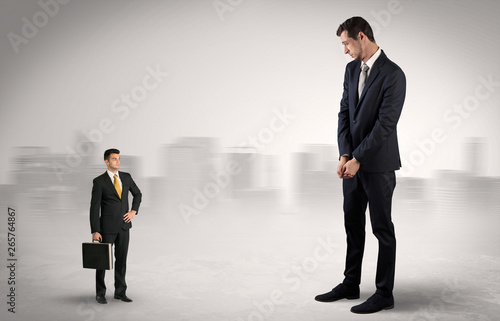 Giant businessman being afraid of small serious executor with suitcase 