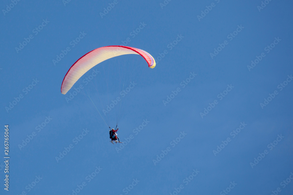 parachute flying side with skies in a cloudless day parachute flying side with skies in a cloudless day