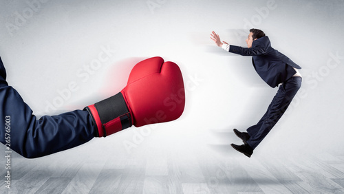 Photography Big red boxing glove knocks out little businessman concept