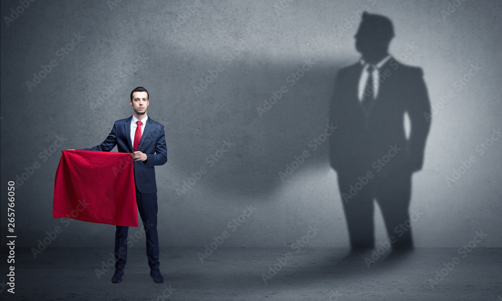 Fototapeta premium Businessman standing with red cloth on his hand and his shadow on the background