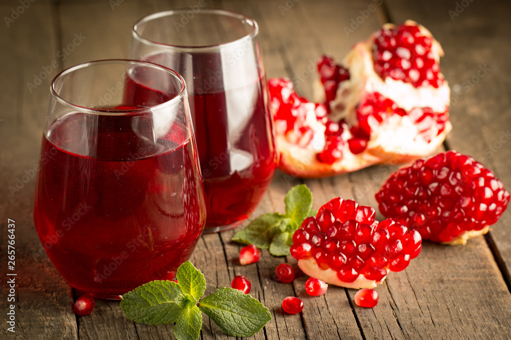 Pomegranate juice with fresh pomegranate fruits on wooden background. soft drink with lime, mint and ice. Pomegranate juice with fresh pomegranate fruits on wooden background. soft drink with lime, mint and ice.