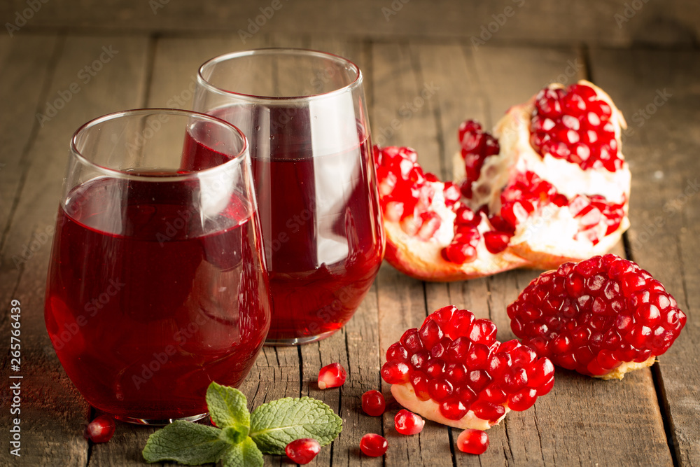 Pomegranate juice with fresh pomegranate fruits on wooden background. soft drink with lime, mint and ice. Pomegranate juice with fresh pomegranate fruits on wooden background. soft drink with lime, mint and ice.