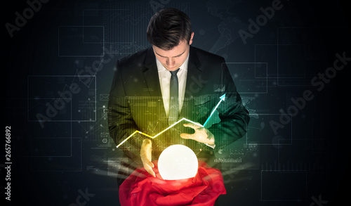 Obraz na płótnie Young businessman making predictions of the future of the stock market with a magic ball
w salonie