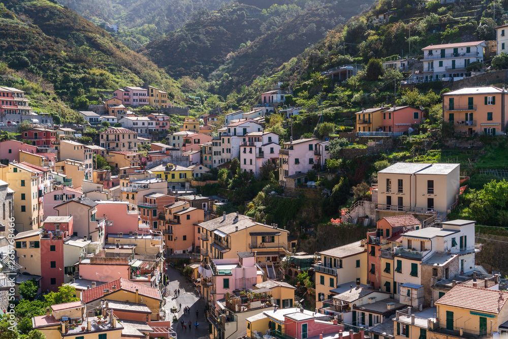 View over the city of Riomaggiore, Cinque Terre, Italy, a popular tourist destination, on a cloudy morning. Colourful old village architecture. Charming Ligurian town. View over the city of Riomaggiore, Cinque Terre, Italy, a popular tourist destination, on a cloudy morning. Colourful old village architecture. Charming Ligurian town.