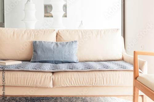 iviry sofa with blanket, cushion at the living room. © dohee