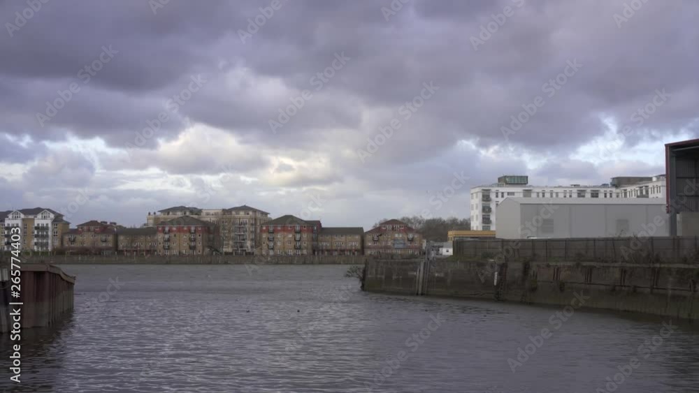 Panoramic of a small bay on the river Thames, London UK. Very cloudy with some industrial buildings on the right. Panoramic of a small bay on the river Thames, London UK. Very cloudy with some industrial buildings on the right.