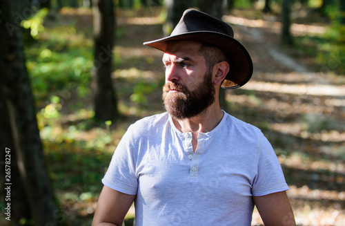 Cowboy couture. Bearded man in cowboy hat walk in park outdoor. man hipster in autumn forest. Spring sunny weather. camping and hiking. mature male with brutal look. bearded man with serious look