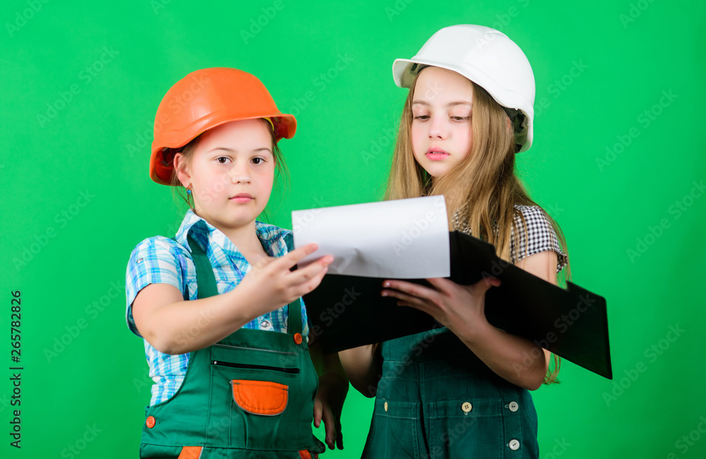 small girls repairing together in workshop. school project. Happy children. Little kids in helmet with tablet. Labor day. 1 may. Foreman inspector. Repair. building workshop. workshop workers small girls repairing together in workshop. school project. Happy children. Little kids in helmet with tablet. Labor day. 1 may. Foreman inspector. Repair. building workshop. workshop workers