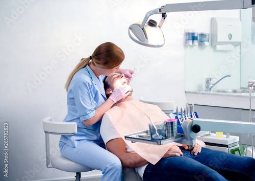 Dentist examining a patient teeth.