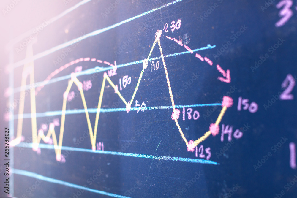 Hands drawing line graph on blue board Hands drawing line graph on blue board