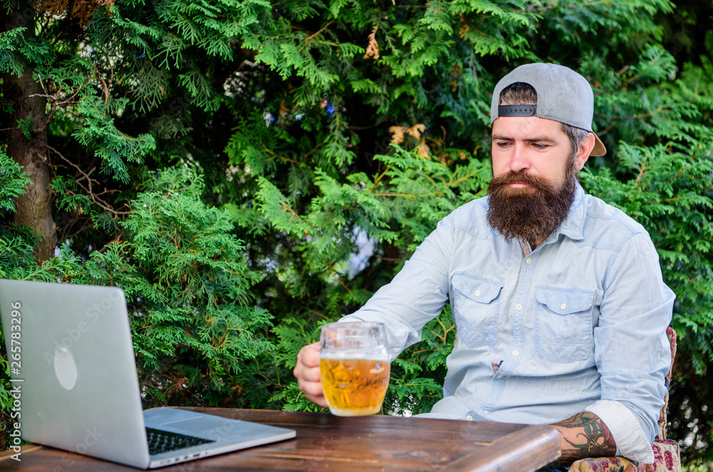 Bearded hipster freelancer enjoy end of working day with beer mug. He deserve this pint. Brutal man leisure with beer and online game. Finally friday. Hipster relax sit terrace outdoors with beer Bearded hipster freelancer enjoy end of working day with beer mug. He deserve this pint. Brutal man leisure with beer and online game. Finally friday. Hipster relax sit terrace outdoors with beer