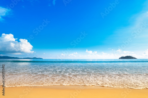 Wide beach with golden sand shore and blue sky