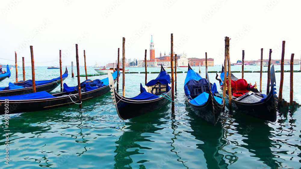 Moored or docked gondolas near the Saint Mark Square with San Giorgio di Maggiore church