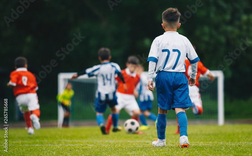 Boys Kicking Football on the Sports Field © matimix