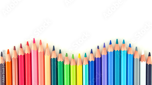 Closeup of coloured pencils lined up in a row on white background copy space