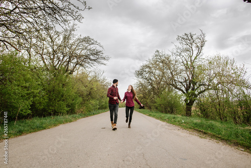 Happy active couple walking and have fun on the country side road
