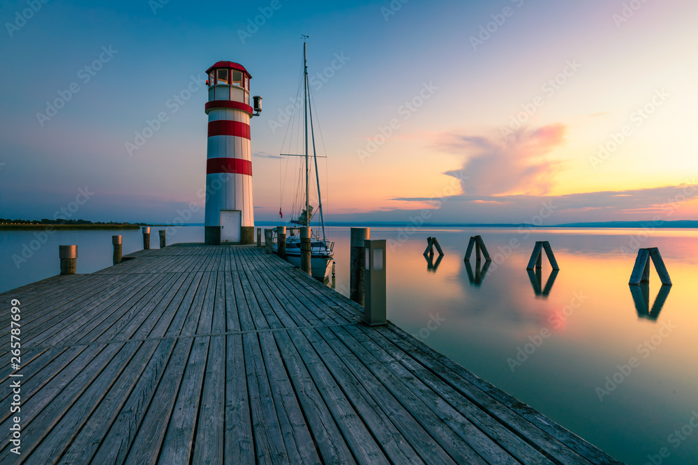Lighthouse at Lake Neusiedl, Podersdorf am See, Burgenland, Austria. Lighthouse at sunset in Austria. Wooden pier with lighthouse in Podersdorf on lake Neusiedl in Austria. - obrazy, fototapety, plakaty 