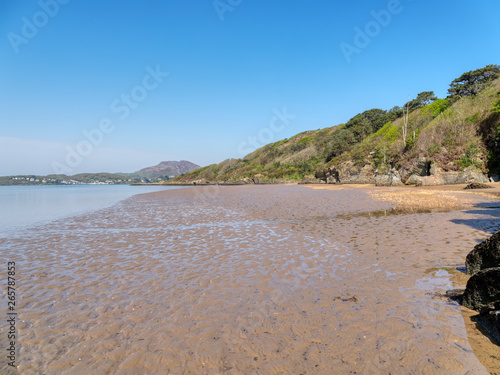 The receding tide leaves wet rippled sand in a small bay on the River Dwyryd estuary