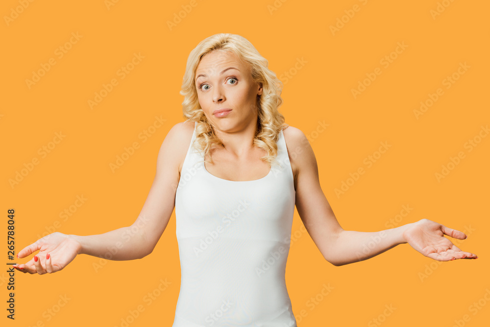 curly blonde woman showing shrug gesture isolated on orange curly blonde woman showing shrug gesture isolated on orange