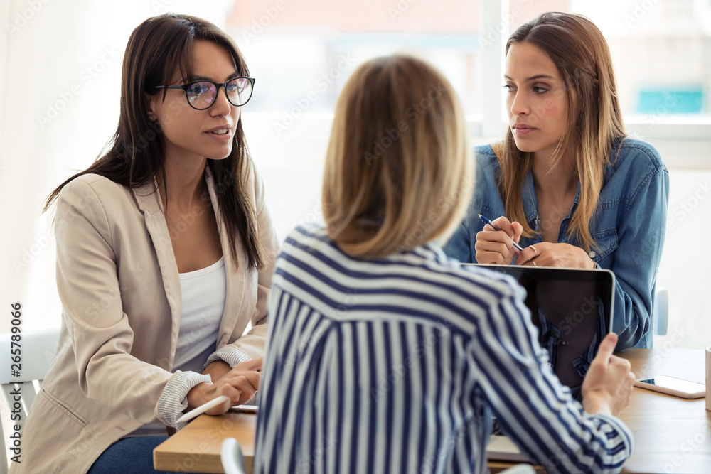 Three business colleagues working together in modern workspace. Brainstorming concept. Three business colleagues working together in modern workspace. Brainstorming concept.