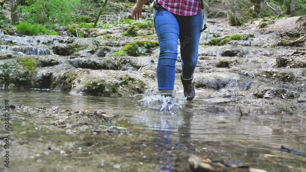 lächelnde junge Frau mit dem Rucksack, beim wandern im wald mit fluss lächelnde junge Frau mit dem Rucksack, beim wandern im wald mit fluss