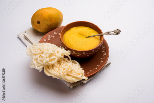 Aam Ras or Alphonso mango pulp with kurdai which is a fried dish made using wheat/gehu. selective focus photo