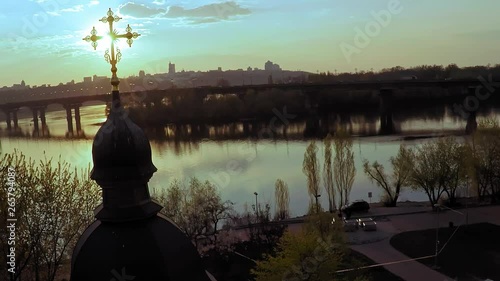 Aerial view of a wooden church with a large golden cross near the wide river Dnieper in Kiev photo