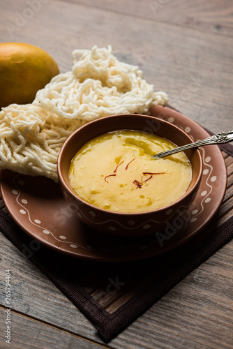 Aam Ras or Alphonso mango pulp with kurdai which is a fried dish made using wheat/gehu. selective focus photo